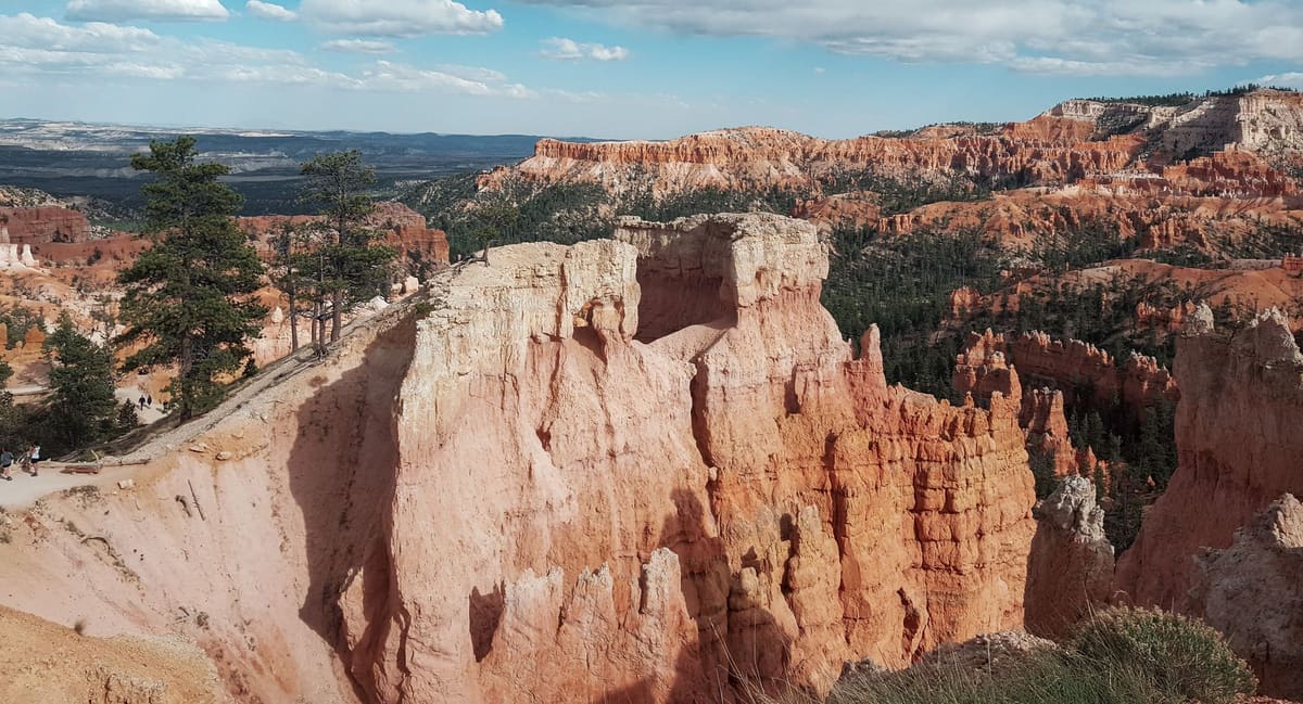 Voiture de location garée face aux canyons rouges typiques du Sud-Ouest américain